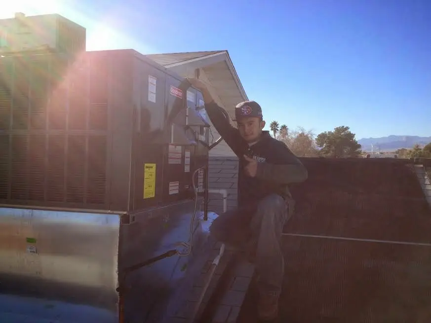 HVAC technician performing HVAC Inspection on a rooftop unit in Petersburg
